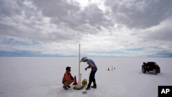State biologists collects water samples in the Bonneville Salt Flats Tuesday, Sept. 13, 2022, near Wendover, Utah. The glistening white salt of the world famous area is shrinking near the Utah-Nevada line. (AP Photo/Rick Bowmer)