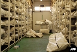 Patolog otkriva jednu od oko 4.000 vreća za tijela koje se čuvaju u ogromnom frižideru u Tuzli, Bosna i Hercegovina, 1. jula 2004. U vrećama se nalaze ostaci tijela muslimanskih muškaraca i dječaka iz grada Srebrenice u istočnoj Bosni koji su masakrirani u 1995. godine.