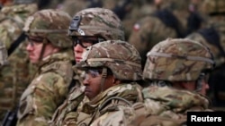 FILE - U.S. soldiers attend a welcoming ceremony for U.S.-led NATO troops at a military training site near Orzysz, Poland, April 13, 2017. 