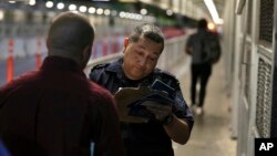 រូបឯកសារ៖ មន្ត្រីគយនិងព្រំដែនកំពុងត្រួតពិនិត្យឯកសារឆ្លងដែនរបស់ជនចំណាកស្រុកម៉ិកស៊ិកដែលស្វែងរកសិទ្ធិជ្រកកោននៅសហរដ្ឋអាមេរិក ខណៈពួកគេចាកចេញពីទីក្រុង Nuevo Laredo នៃប្រទេសម៉ិកស៊ិក កាលពីថ្ងៃទី១៧ ខែកញ្ញា ឆ្នាំ២០១៩។