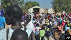 FILE - Women wait for grain to feed their families, at Doro refugee camp in South Sudan.