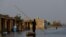 A man rows his boat as he passes through flooded market, following rains and floods during the monsoon season in Bajara village, at the banks of Manchar lake, in Sehwan, Pakistan, Sept. 6, 2022. 