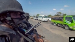 In this image made from video, Rwandan police patrol a road in Palma, Cabo Delgado province, Mozambique, Aug. 15, 2021. A new offensive by Mozambique's Islamic extremist rebels in Cabo Delgado has increased the number of displaced by 80,000 and undermines