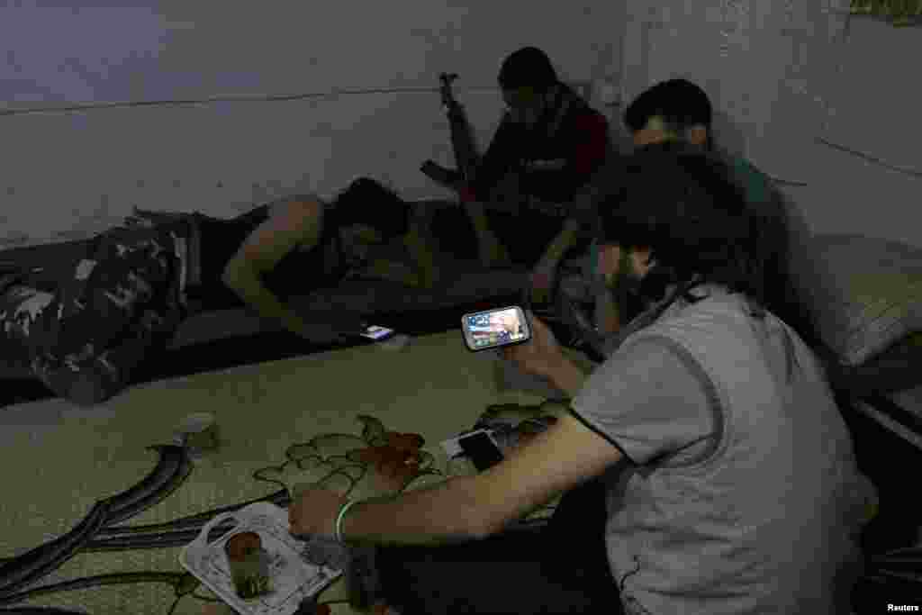 A Harakat Nour al-Din al-Zenki fighter watches on his smart phone&nbsp;news about Donald Trump's election as president, in the rebel held beseiged area in Aleppo, Syria, Nov. 9, 2016.