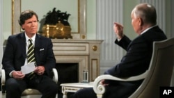 Russian President Vladimir Putin, right, gestures as he speaks during an interview with former Fox News host Tucker Carlson at the Kremlin in Moscow, Russia, Feb. 6, 2024. (Sputnik via AP)