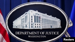 Logo dari Departemen Kehakiman AS terpasang pada podium di ruang pengarahan kantor departemen tersebut di Washington, pada 24 Januari 2023. (Foto: Reuters/Kevin Lamarque)