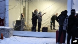 加拿大皇家騎警在魁北克省一個非正規入境者接收中心搜查抵達的移民。（2022年1月12日）