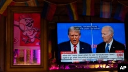 El presidente Joe Biden, a la derecha, y el candidato presidencial republicano, el expresidente Donald Trump, a la izquierda, son vistos en un televisor en Tillie's Lounge durante el debate presidencial el jueves 27 de junio de 2024 en Cincinnati.