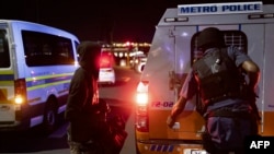 Maafisa Polisi wa Afrika Kusini (SAPS) wakifanya oparesheni huko Johannesburg Februari 19, 2022. Picha na MARCO LONGARI / AFP