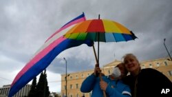 អ្នកគាំទ្រ​ការ​រៀប​អាពាហ៍ពិពាហ៍​របស់​អ្នក​មាន​ភេទដូចគ្នា​ចូលរួម​ការ​ដើរហែក្បួន​មួយ​នៅ​ទីលាន Syntagma ក្នុងទីក្រុង​អាថែន ប្រទេសក្រិក កាលពីថ្ងៃទី១៥ ខែកុម្ភៈ ឆ្នាំ២០២៤។ 