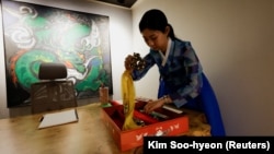 Lee Kyoung-hyun organizes tools for fortune-telling at her shaman parlour in Seoul, South Korea, May 13, 2024. (REUTERS/Kim Soo-hyeon)