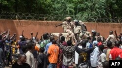 在尼日尔首都尼亚美，支持军政权的抗议者在法国大使馆外聚集并向尼日尔军人欢呼致意。(2023年7月30日)