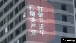 中國山東濟南萬達廣場的高樓外牆上出現遙控打出的打倒共產黨、打倒習近平的標語。(2023年2月21日)