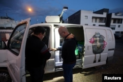 A man buys products outside Pantelis Panteli's van in Nicosia, Cyprus February 1, 2024. (REUTERS/Yiannis Kourtoglou)