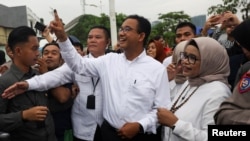 Capres Anies Baswedan menunjukkan jarinya yang telah tercelup tinta setelah menggunakan hak pilih bersama istrinya Fery Farhati Ganis, di TPS Lebak Bulus, Jakarta, pada 14 Februari 2024. (Foto: Reuters/Ajeng Dinar Ulfiana)