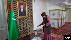 A woman casts her ballot during Turkmenistan's parliamentary elections at a polling station in the town of Annau, some 20 kilometers from the capital Ashgabat, March 26, 2023.