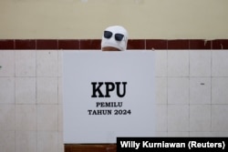 Seorang perempuan memberikan suaranya di TPS saat pemilihan umum, di Surakarta, Jawa Tengah, 14 Februari 2024. (Foto: REUTERS/Willy Kurniawan)