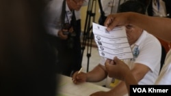 មន្រ្តី​រៀប​ចំ​ការ​បោះ​ឆ្នោត​ម្នាក់​បង្ហាញ​សន្លឹក​ឆ្នោត​ដែល​មាន​គូស​ចំ​គណបក្ស​ប្រជាជន​កម្ពុជា នៅ​មណ្ឌល​​ក្នុង​វិទ្យាល័យ​ព្រះស៊ីសុវត្ថិ ក្នុង​រាជធានី​ភ្នំពេញ នា​ថ្ងៃទី​២៥ ខែ​កុម្ភៈ ឆ្នាំ​២០២៤។ (ស៊ុន ណារិន/វីអូអេ)