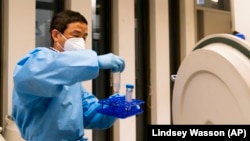 Research scientist Yi Yang retrieves samples at UW Medicine's Cancer Vaccine Institute Thursday, May 25, 2023, in Seattle, Washington. (AP Photo/Lindsey Wasson)