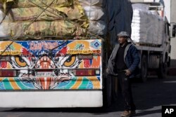 Seorang pengemudi truk Mesir membawa bantuan kemanusiaan untuk Jalur Gaza sedang melewati Penyeberangan Kerem Shalom di selatan Israel, Jumat, 22 Desember 2023. (Foto: Maya Alleruzzo/AP Photo)