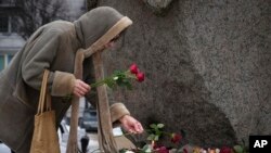 Фото 21 лютого 2024 року: жінка вшановує пам'ять російського опозиціонера Олексія Навльного, який помер у в'язниці 16 лютого у віці 47 років