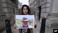 رکسانا طاهباز عکسی از پدر خود را در دست دارد. 