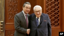 FILE - Chinese Foreign Minister Wang Yi meets former U.S. Secretary of State Henry Kissinger at the Great Hall of the People in Beijing, Nov. 22, 2019.