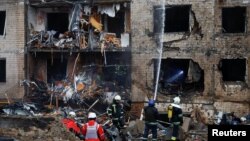 Firefighters work at the site of a residential building damaged during a Russian missile attack in Kyiv, Ukraine, Jan. 2, 2024