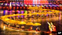 Dalam foto yang dirilis oleh Kantor Berita Xinhua ini, wisatawan menikmati wahana bambu terapung di danau saat perayaan Tahun Baru Imlek di Kabupaten Xuan'en di Provinsi Hubei, China tengah, 11 Februari 2024. (Song Wen/Xinhua via AP)