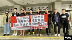 香港社民連8名成員及義工，被當局票控街頭無牌籌款及未經准許而展示海報，他們2月21日在東區裁判法院外拉起橫額示威，抗議當局”法治為名、打壓言論自由”。(美國之音/湯惠芸)