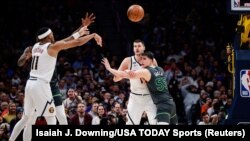 Brus Braun pokušava dodati loptu saigraču iz Denvera Nikoli Jokiću, kojeg čuva Luka Garza, 18. januara 2023. godine.