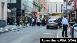 La policía y los bomberos hacen labores de rescate en una calle de Nueva York, EEUU, donde un edificio para estacionamientos se derrumbó el martes 18 de abril de 2023. [Foto: Ronen Suarc, VOA]