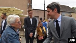 Kryeministri i Francës Gabriel Attal shtërngon duart me një përkrahëse gjatë fushatës në Chatres, Francë, më 2 korrik, 2024, në prag të raundit të dytë të zgjedhjeve parlamentare/AFP