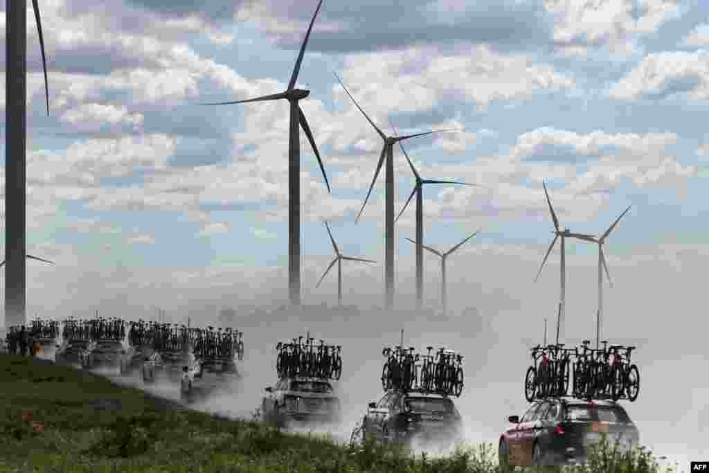 Team direction vehicles with bicycles on their roofs drive through dust over the Plateau de la Cote des Bar "Chemin Blanc" (white road) gravel sector during the 9th stage of the 111th edition of the Tour de France cycling race, 199km stage departing and finishing in Troyes, France.