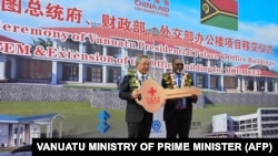 瓦努阿图总理办公室2024年7月2日发布图片显示，中国全国政协副主席胡春华在瓦努阿图新总统府正式移交给瓦努阿图政府的仪式上向瓦努阿图总理萨尔瓦伊（右）递交钥匙。