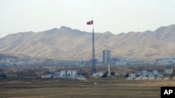 FILE - North Korea's flag flies on a tower high above the village of Ki Jong Dong, as seen from Observation Post Ouellette in the Demilitarized Zone, DMZ, the tense military border between the two Koreas, in Panmunjom, March 25, 2012. (AP Photo/Susan Walsh, File)