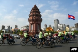 អ្នកធាក់ស៊ីក្លូ​កំពុង​ដឹក​ភ្ញៀវទេសចរកាត់វិមាន​ឯករាជ្យ​ នៅរាជធានីភ្នំពេញ កាលពីថ្ងៃទី១៦ ខែកុម្ភៈ ឆ្នាំ២០២៤។