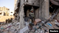 Tentara Israel berdiri di tengah reruntuhan, selama invasi darat Israel di Jalur Gaza utara, 8 November 2023. (Foto: REUTERS/Ronen Zvulun)