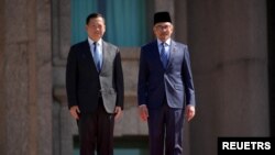 នាយករដ្ឋមន្ត្រីកម្ពុជាលោក ហ៊ុន ម៉ាណែត និង​នាយករដ្ឋមន្ត្រី​ម៉ាឡេស៊ីលោក Anwar Ibrahim ថតរូបជាមួយគ្នា ក្នុងអំឡុងពិធីទទួលស្វាគមន៍លោក ហ៊ុន ម៉ា​ណែត នៅ​ទីក្រុង Putrajaya ប្រទេសម៉ាឡេស៊ី កាលថ្ងៃទី២៧ ខែកុម្ភៈ ឆ្នាំ២០២៤។ (Vincent Thian/Pool via REUTERS)