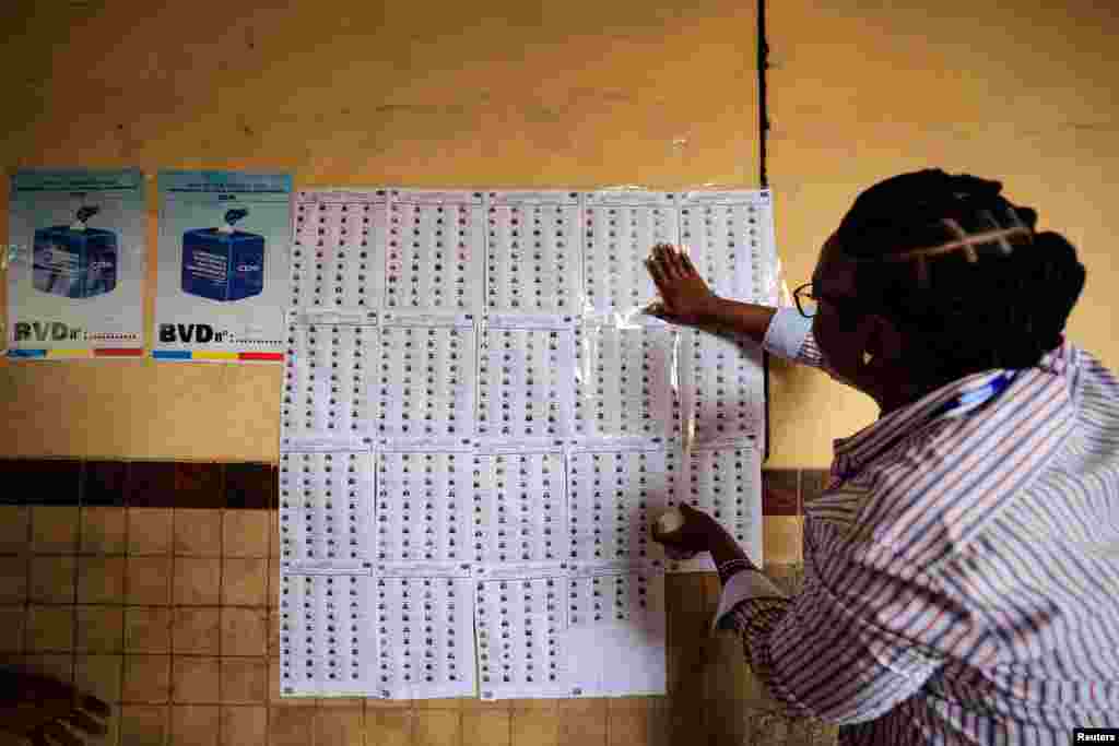 Umwe mu bagize komisiyo y'igihugu ijejwe amatora muri Kongo, amanika intonde z'abiyandikishije gutora.