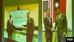 華府玉山科技協會展示富士康創辦人郭台銘（左）與美國馬里蘭州立大學校長達瑞爾·派恩斯簽訂工業人工智能合作備忘錄照片。（2023年3月28日，美國之音鍾辰芳拍攝）