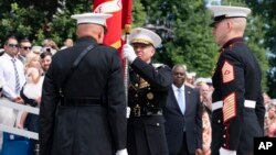U.S. Marine Corps Gen. David Berger, left, hands the battle colors to Gen. Eric Smith during a relinquishment of office ceremony, at the Marine Barracks in Washington, July 10, 2023. 
