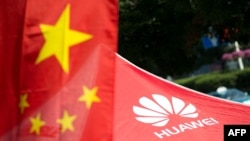 资料照片：中国国旗与华为标识。