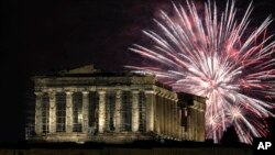 Fireworks explode over the ancient Parthenon temple at the Acropolis hill during New Year's celebrations in Athens, Greece, Jan. 1, 2024.