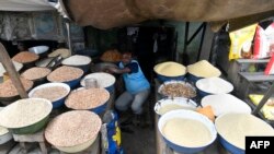 បុរស​ម្នាក់​កំពុង​អង្គុយនៅ​តូប​របស់​ខ្លួន​ក្នុង​ផ្សារ​ Lagos កាលពីថ្ងៃទី​២៦ ខែកក្កដា ឆ្នាំ២០២៣។