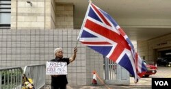 资料照片: 2023年11月29日社运人士王婆婆在西九龙裁判法院示威区内，独自一人手持英国旗及标语，要求释放47、释放所有政治犯 (美国之音/汤惠芸)