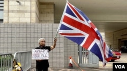 香港民主派初選47人被控國安法下串謀顛覆國家政權案，11月29日開始口頭結案陳詞，社運人士王婆婆在西九龍裁判法院示威區內，獨自一人手持英國旗及標語，要求釋放47、釋放所有政治犯。(美國之音湯惠芸)