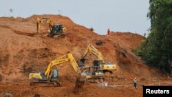 Sejumlah pekerja dan alat berat berada di lokasi konstruksi yang akan menjadi pelabuhan di dekat Teluk Balikpapan, pada 7 Maret 2023. Pelabuhan itu nantinya akan terhubung dengan ibu kota baru Nusantara, Penajam Paser Utara, Kalimantan Timur. (Foto: Reuters/Willy Kurniawan)