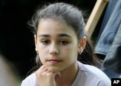 Milana Minenko, a 9-year-old child from Ukraine, glances to the side during an interview with The Associated Press, in Warsaw, Poland, Wednesday June 7, 2023. (AP Photo/Czarek Sokolowski)