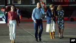 Predsednik Džo Bajden priča telefonom pre ukrcavanja na predsednički avion Er fors 1, u vazdušnoj bazi Megvajer, u okrugu Barlington, u Nju Džersiju, 29. juna 2024. S leva: Natali Bajden, predsednik Džo Bajden, Finegan Bajden i prva dama Džil Bajden